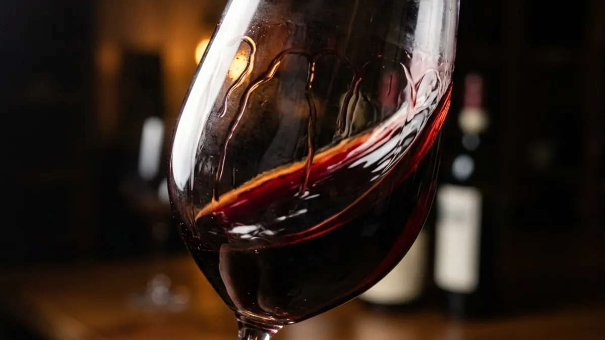 Taça de Cabernet Sauvignon sendo girada com cor rubi profundo