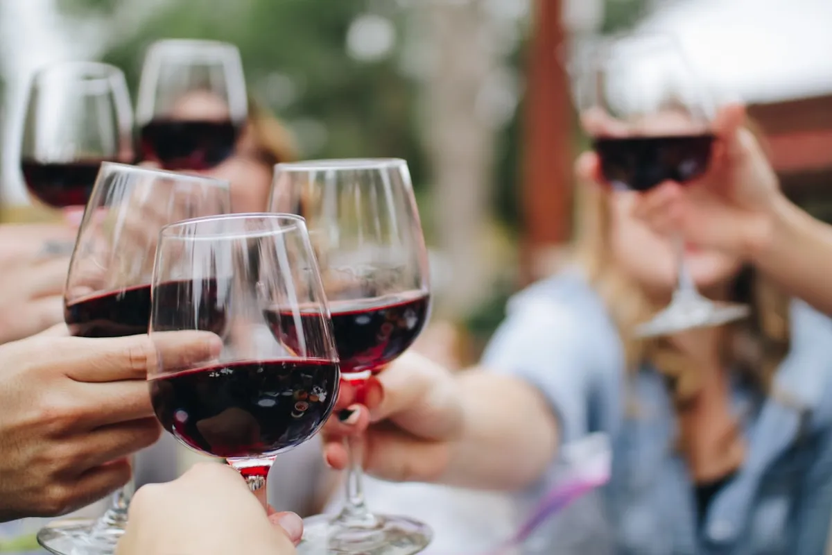 Três taças de vinho tinto lado a lado mostrando diferentes intensidades de cor